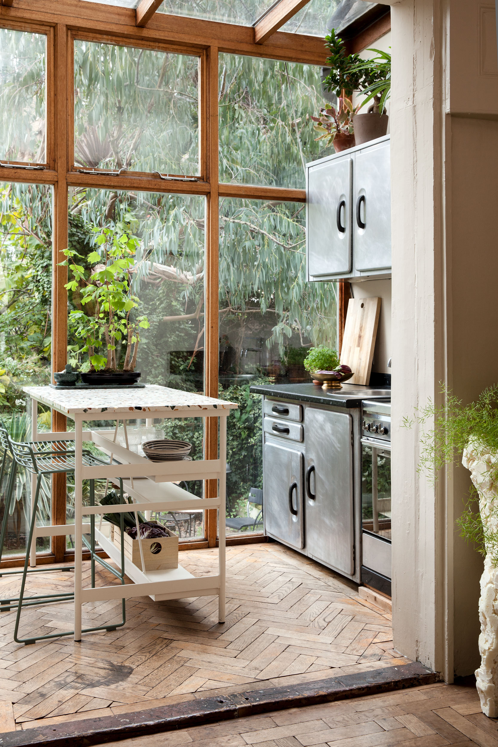 Glazed kitchen with a terrazzo table and garden views