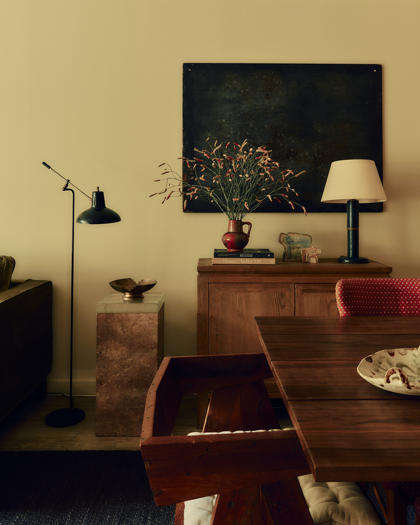 Dining area with red chairs and collected art