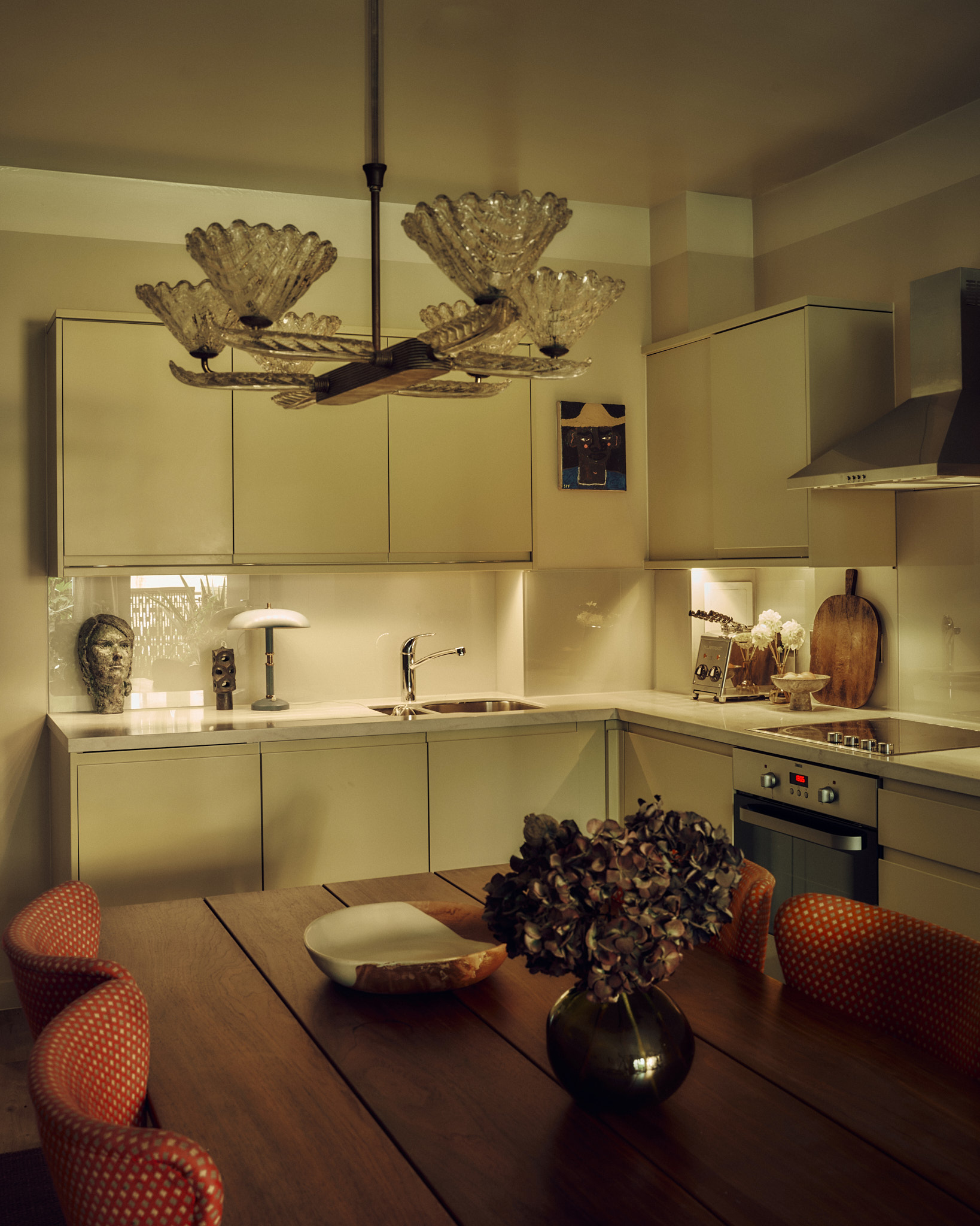 Wintergreen kitchen beneath a sculptural chandelier